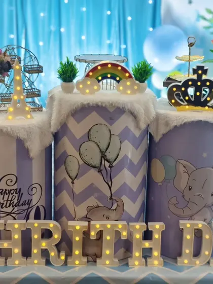 Themed pedestals from Dhrith's elephant party, decorated with light-up props like a crown, rainbow, and Eiffel Tower.