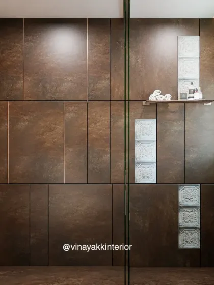 A detail shot of the shower area, showcasing the contrast between the large, dark industrial-style panels and the delicate, patterned glass blocks. This combination adds visual interest and a sense of custom craftsmanship.