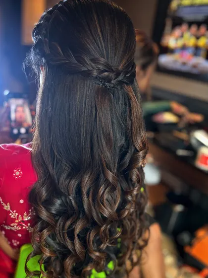 A still image capturing the detail of the braided crown and the texture of the curls.