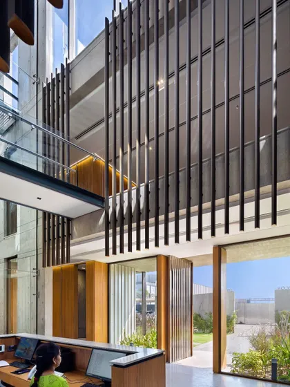 The reception area at Laxcon features a suspended screen of vertical steel elements, a direct nod to the company's core product, blending industrial identity with refined interior design.