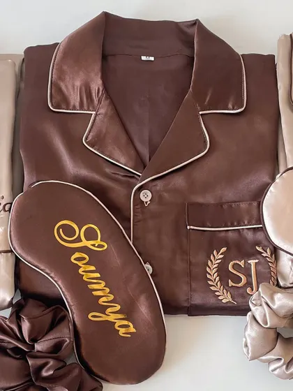 This brown satin pajama set for 'Soumya' is customized with her name on the eye mask and her initials embroidered on the pocket.