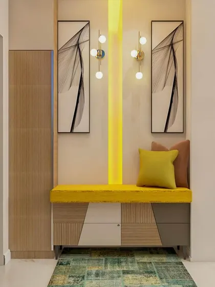 This vibrant foyer design uses a bright yellow cushioned bench with patterned storage cabinets below. The vertical light strip and modern art create a cheerful and welcoming entrance that is full of personality.