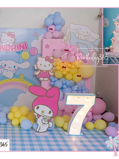 A sweet Hello Kitty and Friends party setup for Nandhini's 7th birthday, featuring a large marquee number and a pastel blue and pink color scheme.