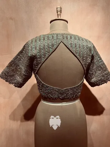 The back of the ice blue blouse, showcasing the unique cutout and ornate embroidery.