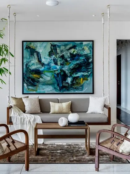 The indoor swing is a beloved feature in the Terrazzo Residence. Paired with classic wooden armchairs and a large piece of abstract art, it creates a relaxed yet sophisticated corner for reading or conversation.