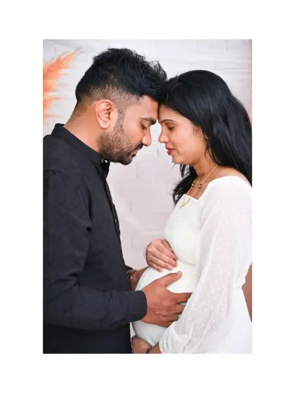 The same intimate black and white portrait, presented here in full color. The warm tones of the background and their skin create a soft and gentle mood, highlighting their connection.