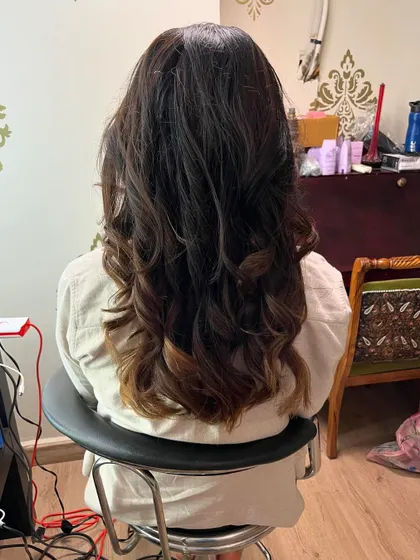 The back view shows the full length and volume of her hair.