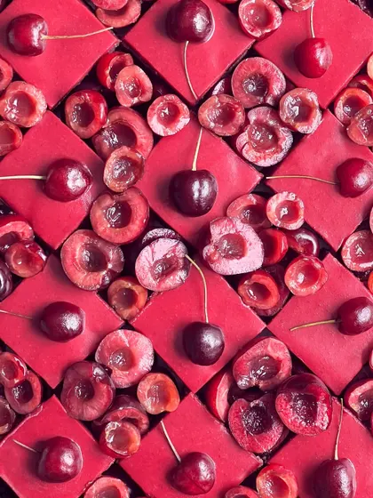My cherry opera gateau is a true showstopper. The vibrant red of the cake, made with real cherries, is arranged in a beautiful pattern with fresh, juicy cherries.