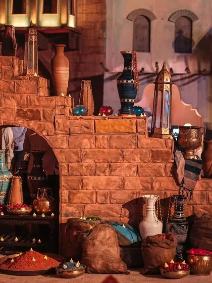 A recreation of a marketplace from old Arabia, complete with textured stone walls, clay pots, and rustic textiles. This area served as a photo backdrop and an interactive space for guests.