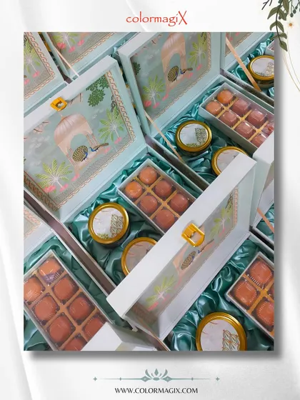 An overhead view of our elegant wedding sweet boxes. The transparent lid with a classic Indian architectural motif offers a glimpse of the delicious motichoor laddoos inside.