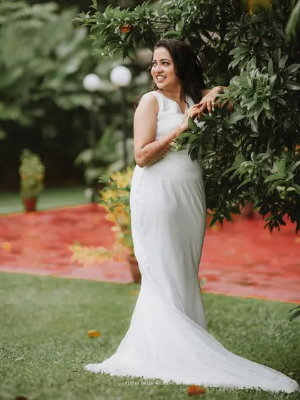 An elegant portrait of the bride in her white gown, posing gracefully in a garden.