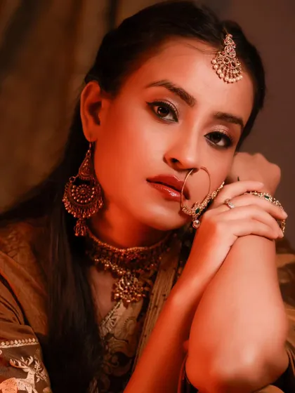 An intimate and captivating close-up. The warm, soft light highlights her beautiful features and the intricate details of her jewelry.