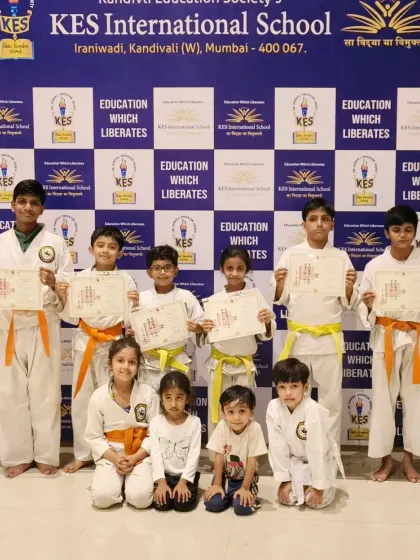 A large group from our KES International School program celebrating their new belts. It's wonderful to see students of different levels supporting each other.