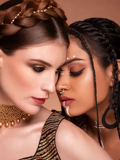 A powerful image exploring themes of duality and cultural fusion. The contrast between the two models' makeup styles, one classic and one tribal, creates a compelling narrative about the many faces of beauty.