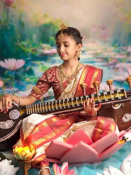 A close-up of a young girl dressed as Goddess Saraswati, her expression full of grace and wisdom.