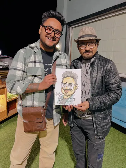 Here I am with a happy client and his new caricature. Being able to connect with people and share a laugh through my art is the best part of what I do.