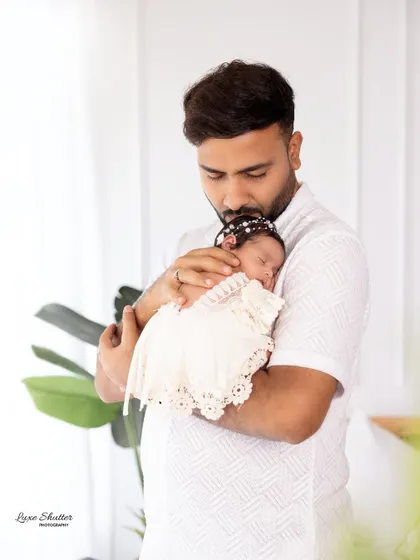 A father gently kissing his newborn's head. This is a simple, powerful expression of love and protection.