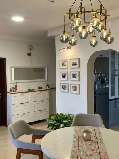 Another shot from the same home, showing the dining area with a statement chandelier and a gallery wall.