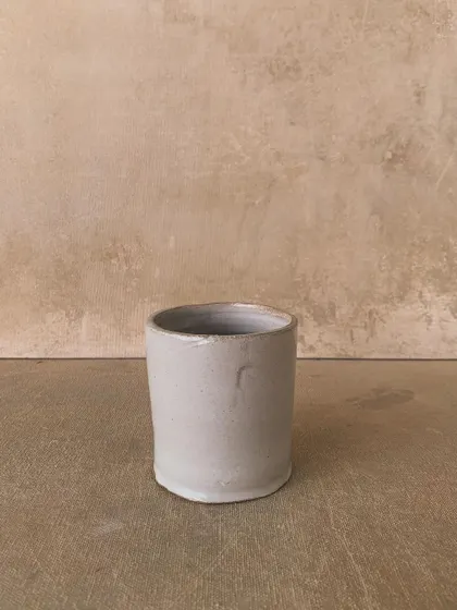 A simple, unglazed pot with a clean, minimalist form. This piece celebrates the beauty of the raw clay itself.