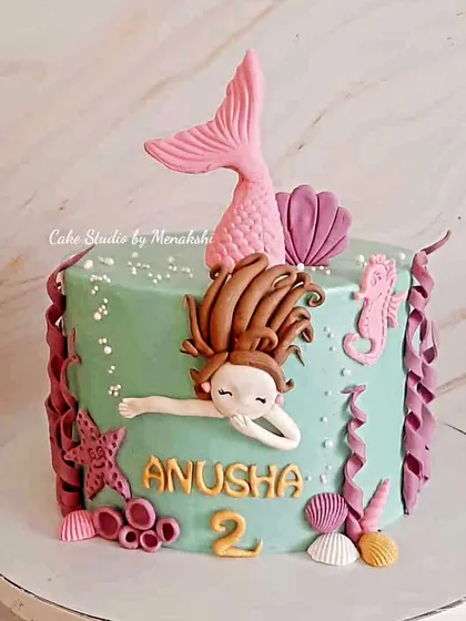 A pretty mermaid themed cake for Anusha turning two. This design features a swimming mermaid with a pink tail, surrounded by handcrafted shells, starfish, and seaweed.