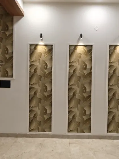 Wallpaper installed in vertical niches creates a stunning visual effect. Here, a dark leaf pattern is illuminated by spotlights, turning these architectural features into works of art.