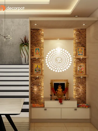 A beautiful example of an open pooja niche. The design uses a stone-textured backdrop and a backlit Om mandala, with floating shelves on either side for placing idols and photos.