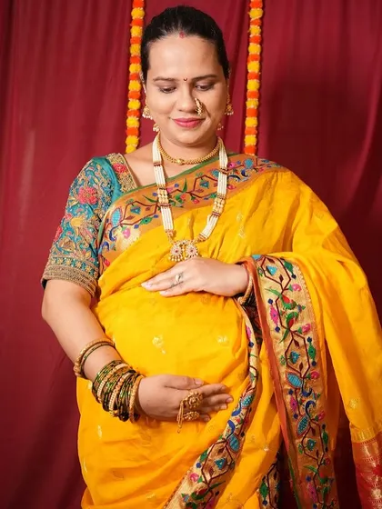 A close-up of the mom-to-be in a beautiful yellow Paithani saree, a classic choice for traditional photoshoots.