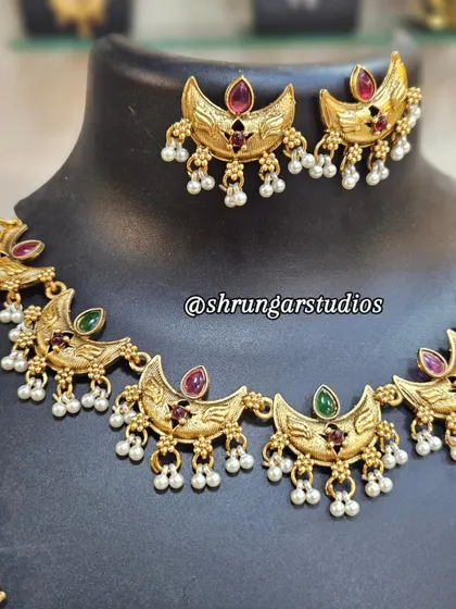 This Chandra (moon) motif copper combo set is a trending piece. It's lightweight and looks beautiful with Paithani sarees.