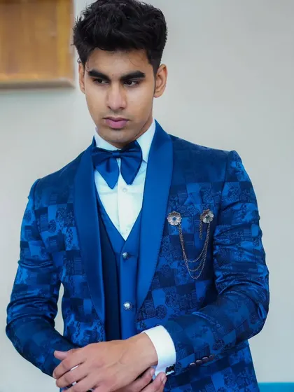 A model looking sharp in our royal blue patterned tuxedo. The matching blue bow tie and the brocade-like fabric make it a complete, high-fashion look.