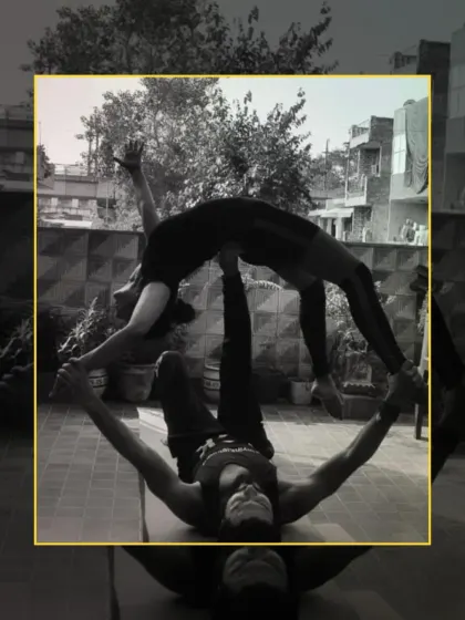 A stunning black and white shot of a partner backbend in acro yoga, highlighting the lines, strength, and trust between the base and flyer.