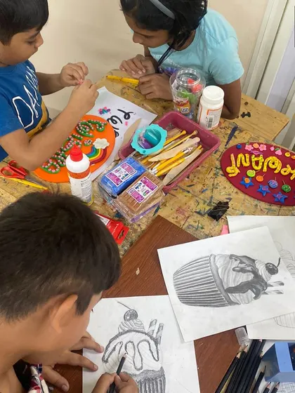 Our studio is a space for artists of all ages to learn together. Here, younger students work on clay crafts while an older student practices their pencil shading and drawing skills.
