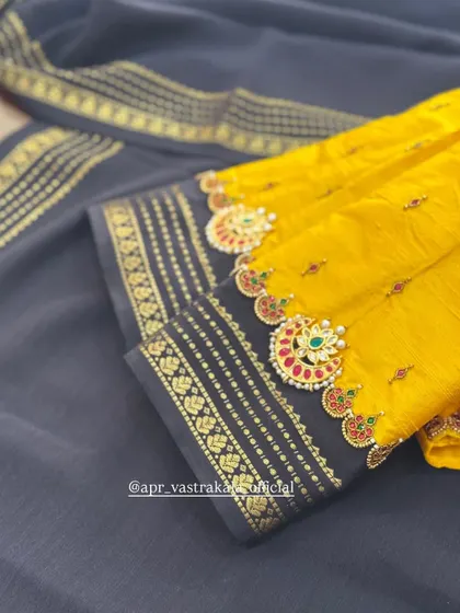 A bright yellow blouse with contrasting navy blue cuffs, adorned with temple jewellery motifs.