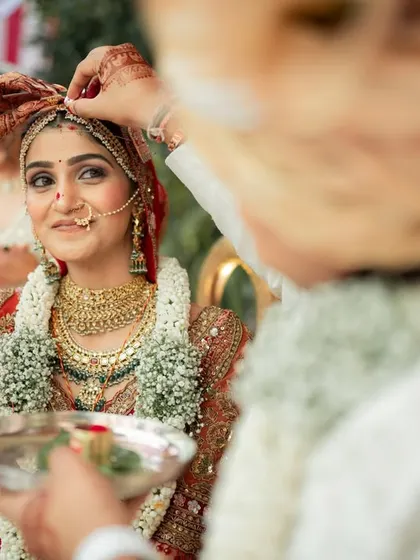 A beautiful moment as the groom helps the bride with her jewelry during the ceremony, a small gesture of care and love.