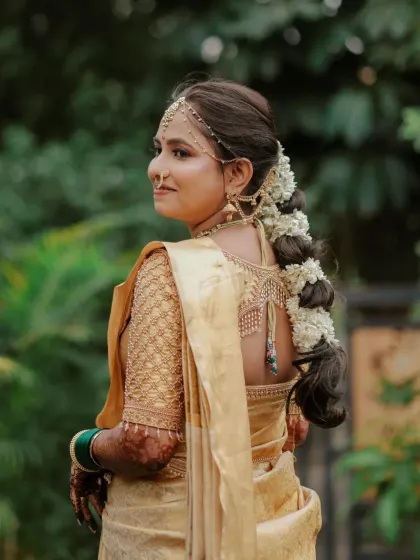 A detailed look at the back of Dhanashree's hairstyle, featuring a thick braid adorned with fresh jasmine flowers (gajra), a staple for Marathi brides.
