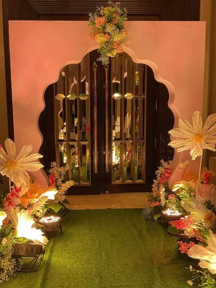 We created a magical entrance for the cradle ceremony, lining a green turf walkway with oversized, illuminated paper flowers and leading to a grand, floral-adorned archway.