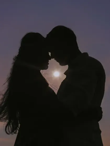 A stunning silhouette of a couple against a sunset, showcasing our artistic approach to creating dramatic and romantic pre-wedding portraits.