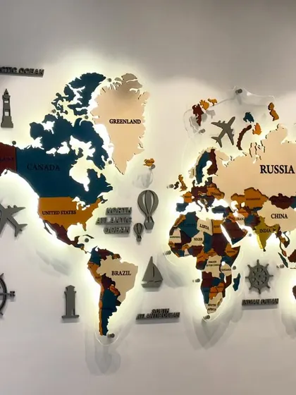 The backlit world map mural, shown here with the lights on. The warm glow outlines the continents, creating a visually striking piece for any office or study.
