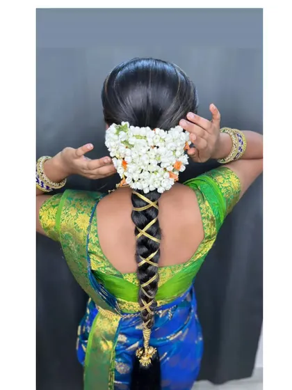 A simple and sweet traditional braid with a gold ribbon criss-cross, finished with a jasmine gajra.