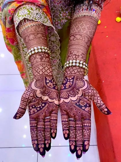 The stunning dark purple-black stain of a bridal mehendi, complemented by the bride's jewelry.