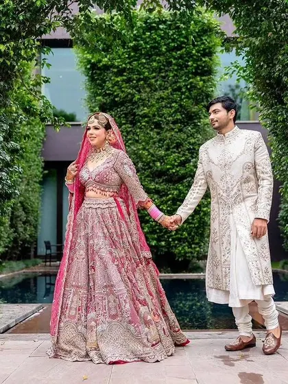 The couple taking a walk in the beautiful gardens of their wedding venue.