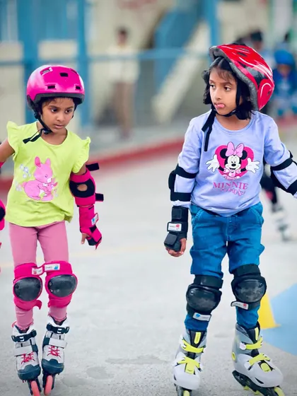 Two friends and teammates getting ready for their turn. The social aspect of our skating classes is just as important as the physical training, helping kids build lasting friendships.