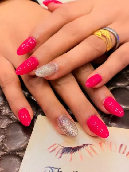 A bright and cheerful set of hot pink almond nails. The ring fingers are accented with a full coat of silver glitter for a classic glam look.