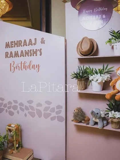 A softer take on the jungle theme, using a pastel pink backdrop and a shelf display with cute stuffed animals and plants.