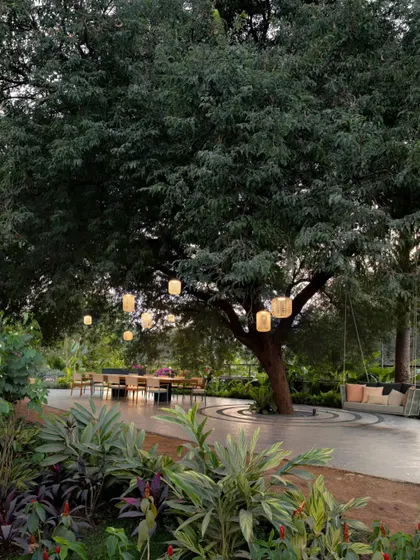 A wider perspective of the outdoor dining area, where our custom pendant lights create a serene and inviting glow as dusk settles. The lighting transforms the landscape into an exterior room.