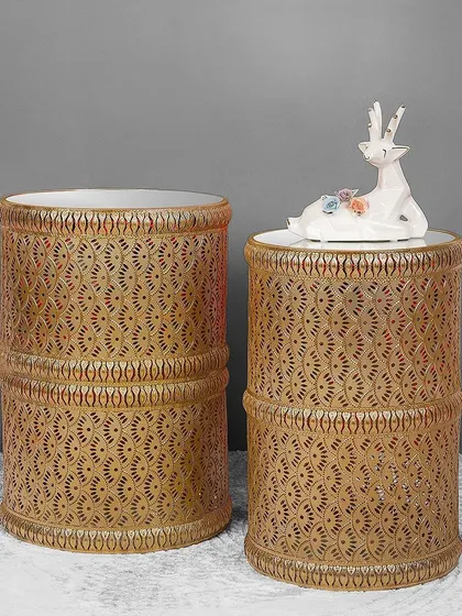 This set of two cylindrical side tables features a beautiful gold lattice design. They can be nested or used separately, offering versatile surfaces for drinks, lamps, or decor.