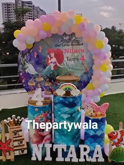 A full view of the rooftop mermaid party, showing the complete setup with an artificial grass floor and city views.