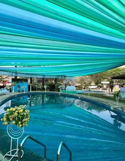 We can transform any space, including a poolside area, into a spectacular event venue. For this Haldi ceremony, we installed a beautiful blue and green fabric canopy over the pool, which not only looked stunning but also provided shade for the guests.