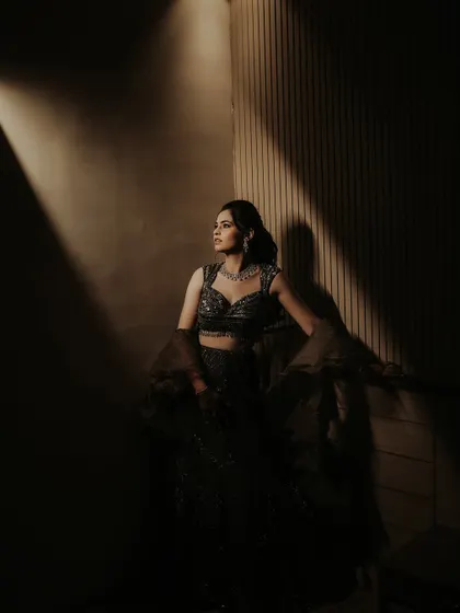 The bride looks away from the camera in this beautifully lit portrait. The shadows and warm light create a sense of quiet contemplation and elegance amidst the Sangeet festivities.