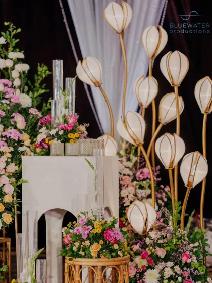 A close-up of the illuminated floral lamps and the surrounding flower arrangements.