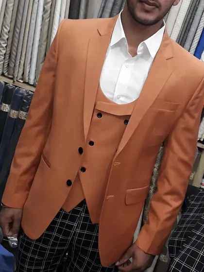 A unique combination of a solid orange blazer and waistcoat with patterned trousers. I can help you create custom looks that reflect your style.